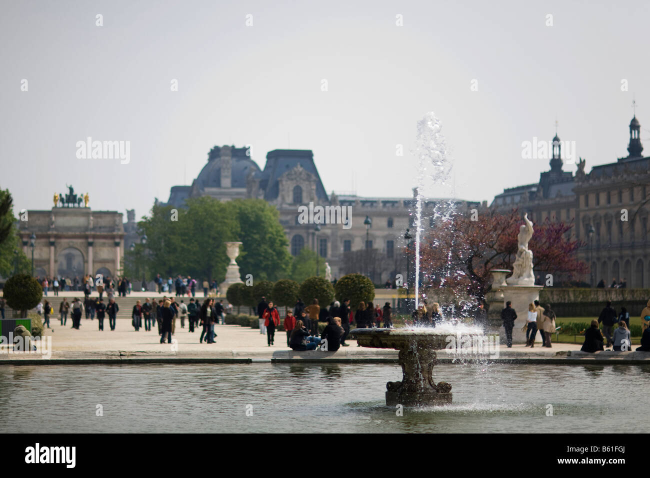 Une fontaine dans le Jardin des Tulleries à Paris, à la recherche de retour sur le musée du Louvre et l'Arc de triomphe du Carrousel Banque D'Images