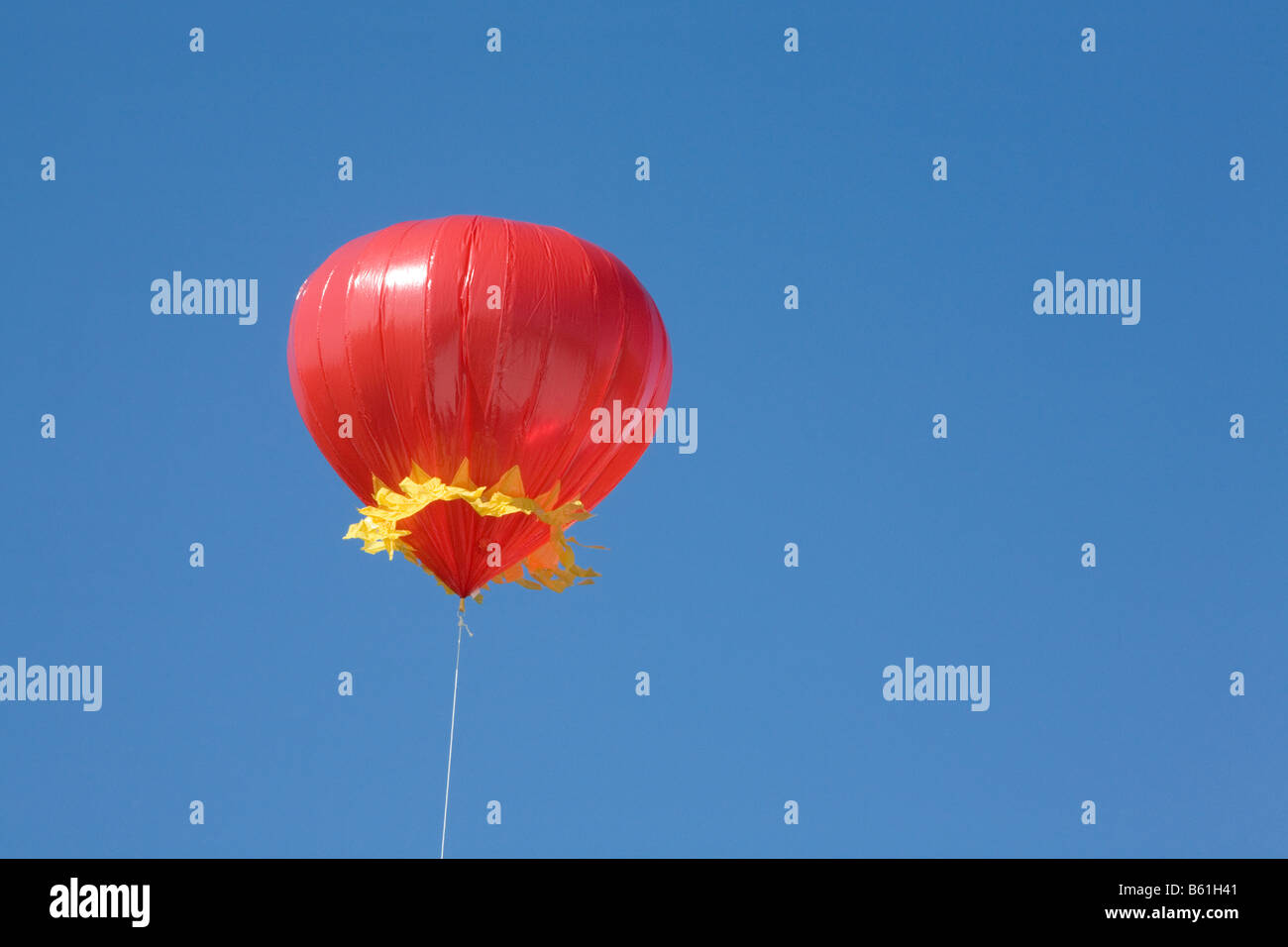 Ballon rouge intégré contre un ciel bleu Banque D'Images