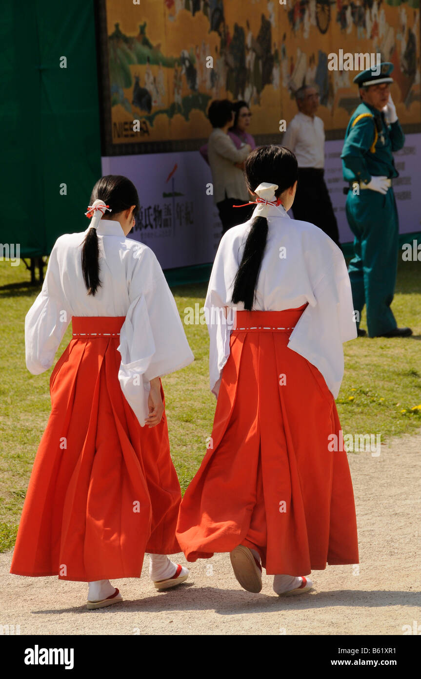 Temple Shinto shrine maidens ou fonctionnaires, appelé Mikos, en kimono traditionnel Chihaya avec rouge écarlate Hakama et Kimono blanc Banque D'Images