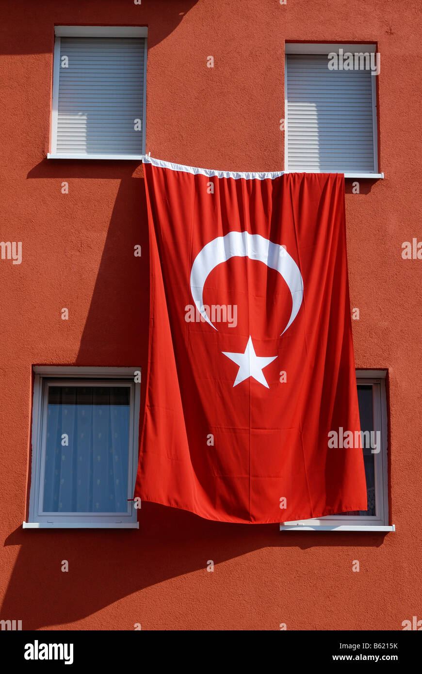 Drapeau national turc accroché au mur d'un immeuble à appartements Banque D'Images