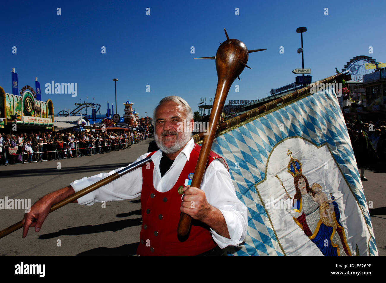 Homme portant un drapeau bleu et blanc lors d'un costume traditionnel cortège, les Smith de Kochel, Wies'n, l'Oktoberfest, Munich, B Banque D'Images