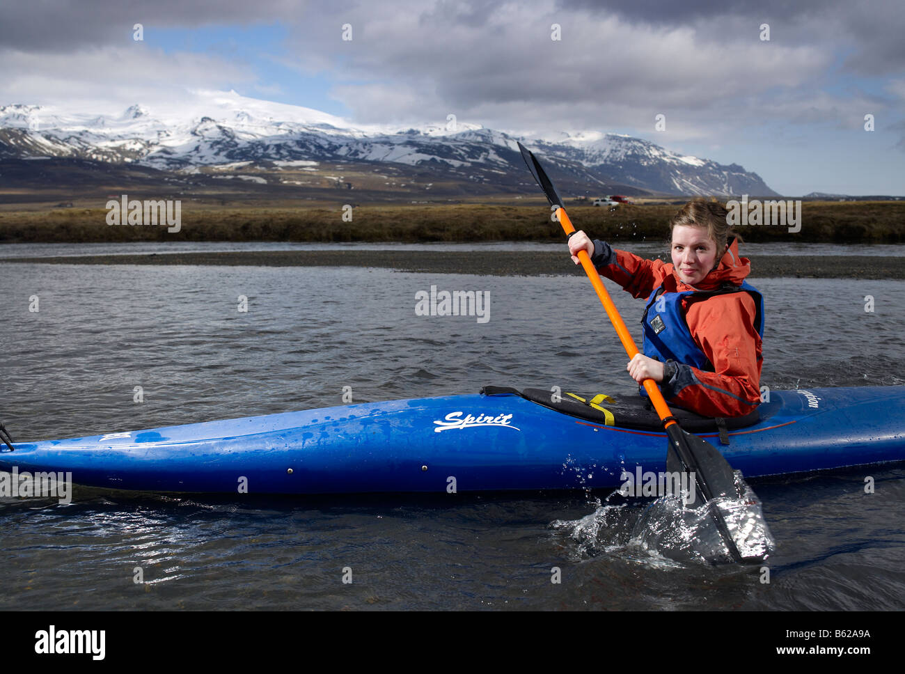 Teenage girl kayak en rivière avec Oraefajokull glacier dans l'arrière-plan, l'Est de l'Islande Banque D'Images