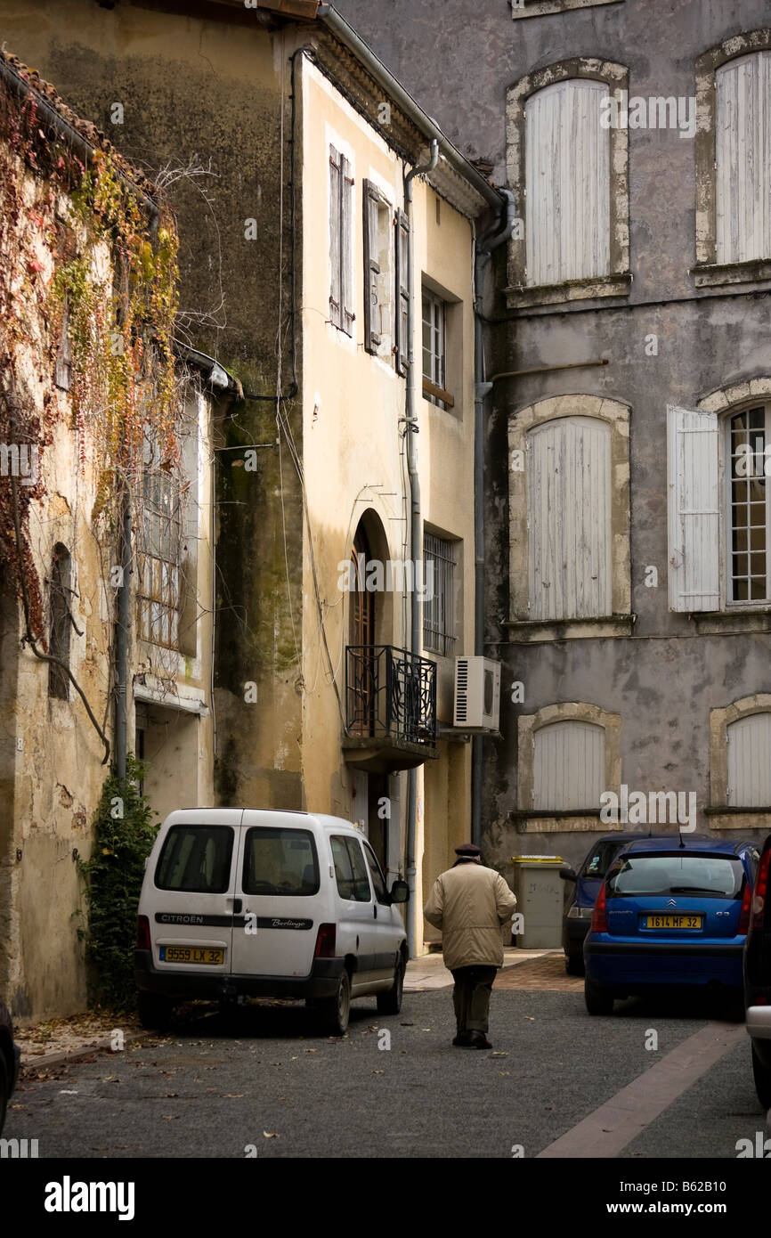 Homme marchant à sa maison de ville traditionnelle française, Eauze, Gers, dans le sud de la France Banque D'Images