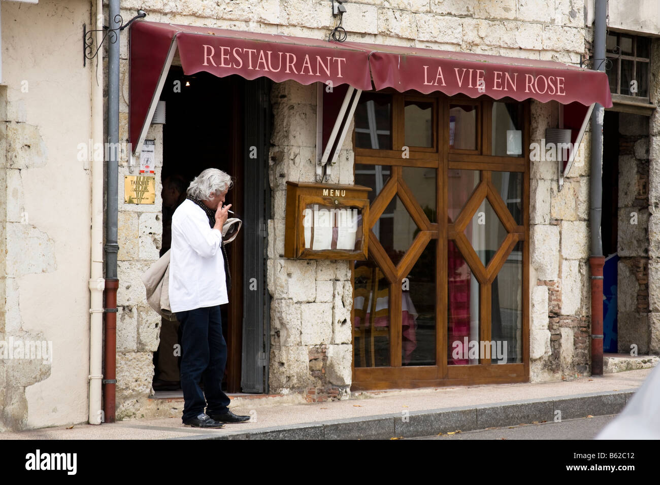 Man smoking restaurant à l'extérieur, d'Eauze - Gers, dans le sud de la France Banque D'Images
