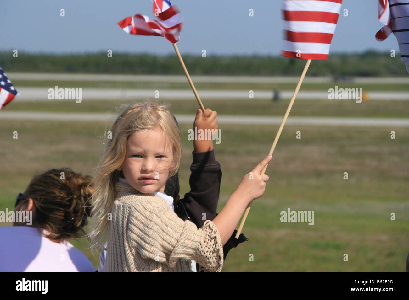 Jeune américaine blonde girl Waving Flag avec breeeze soufflant ses cheveux Banque D'Images
