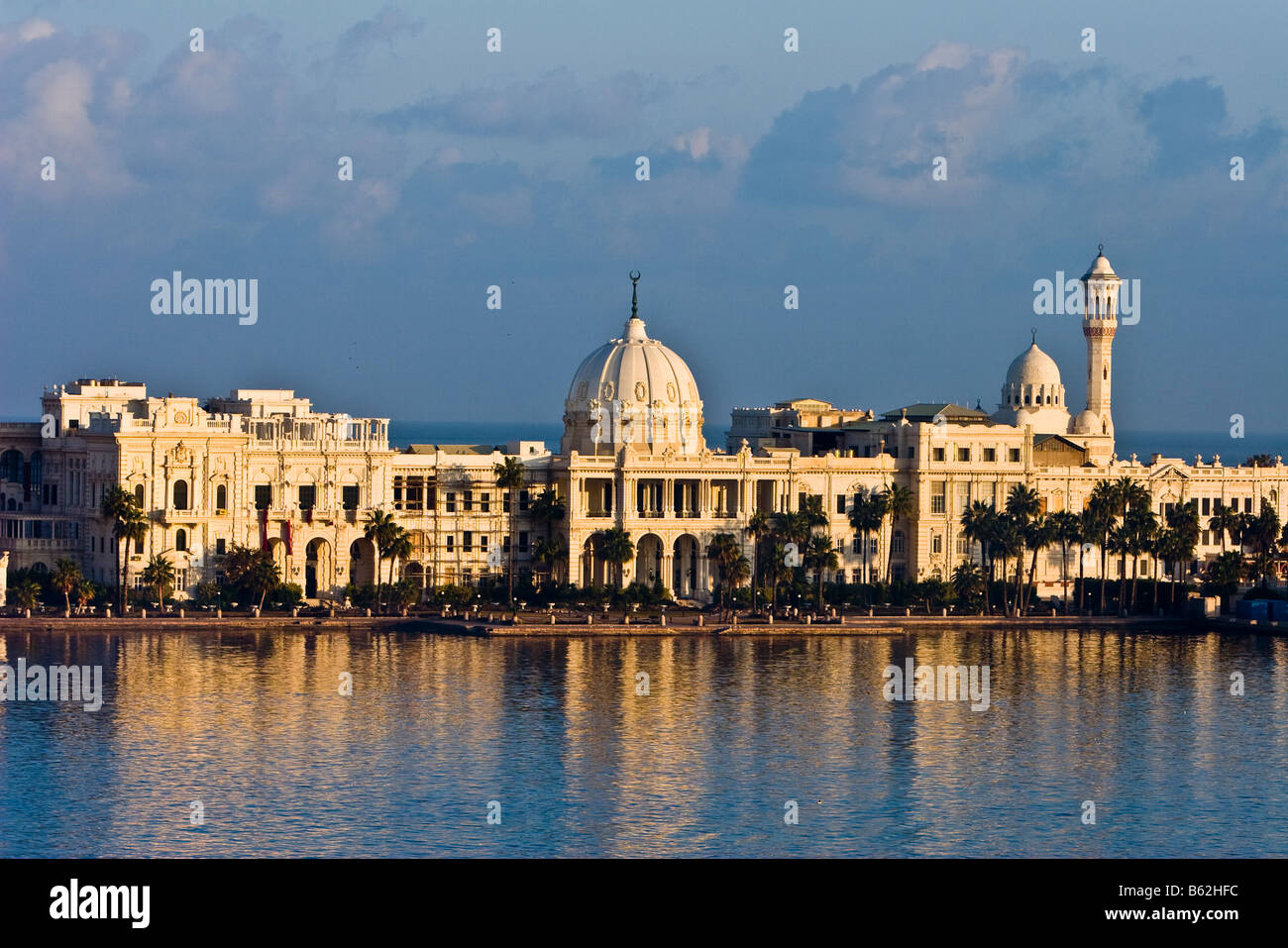 Le soleil se lève sur Ras el-Tin palace à Alexandrie en Égypte, et sa réflexion est jeté dans les eaux du port. Banque D'Images