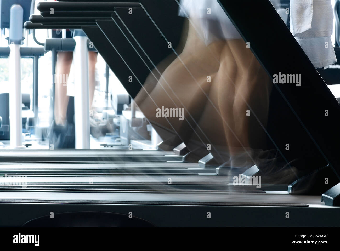 Personne qui exerce sur une machine de tapis roulant dans une salle de sport Banque D'Images