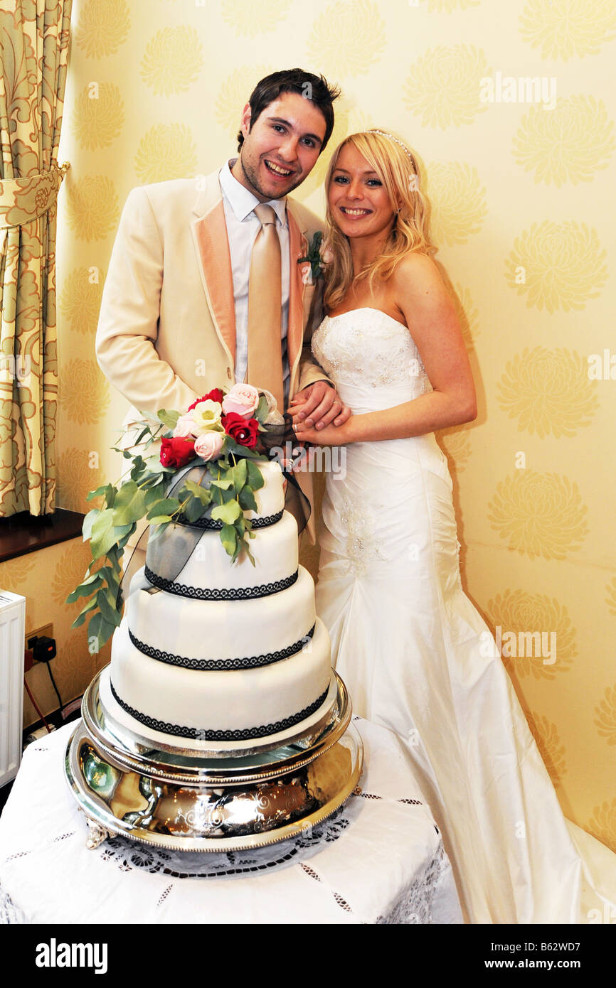 Couple de jeunes mariés, West Yorkshire avec leur modèle de gâteau de mariage publié Banque D'Images