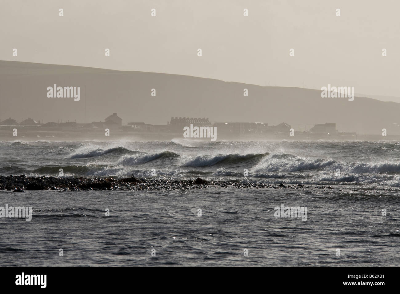 La mer d'Irlande vagues se briser à Tywyn, Gwynedd, tôt le matin soleil d'hiver. Banque D'Images