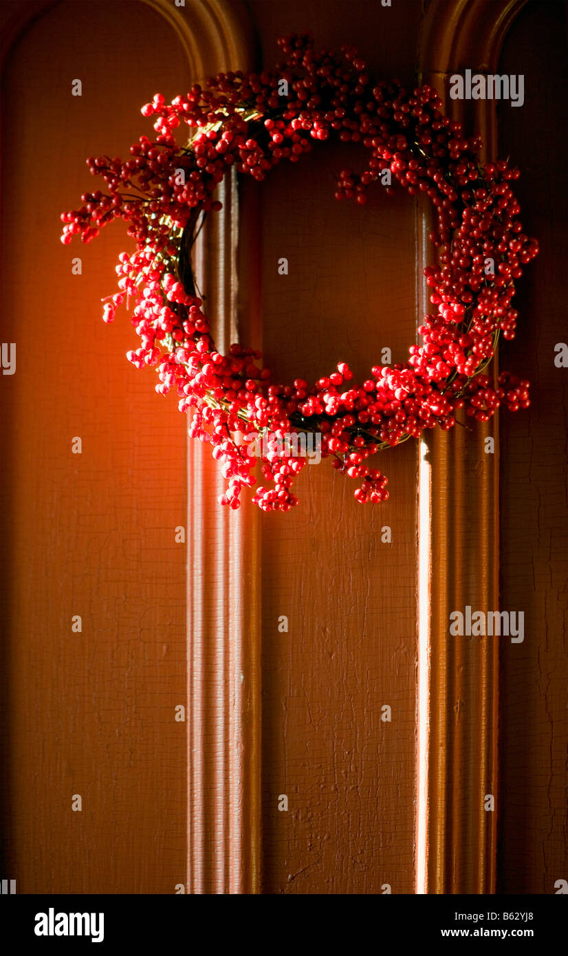 Couronne de Noël de canneberges sur une porte orange. Banque D'Images