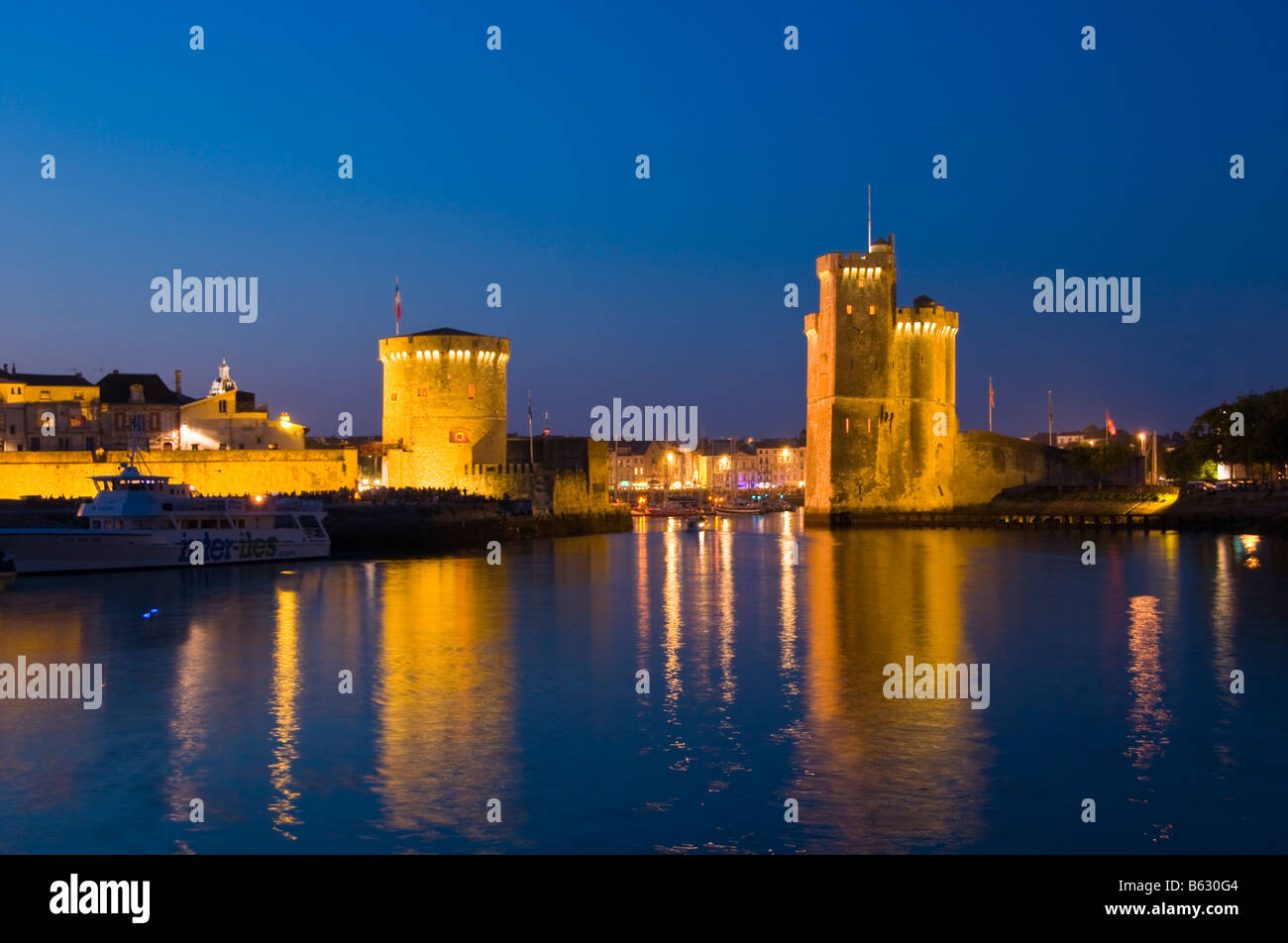 La chaîne et les tours St Nicolas à l'entrée de l'ancien port de La Rochelle la nuit Charente Maritime France Banque D'Images