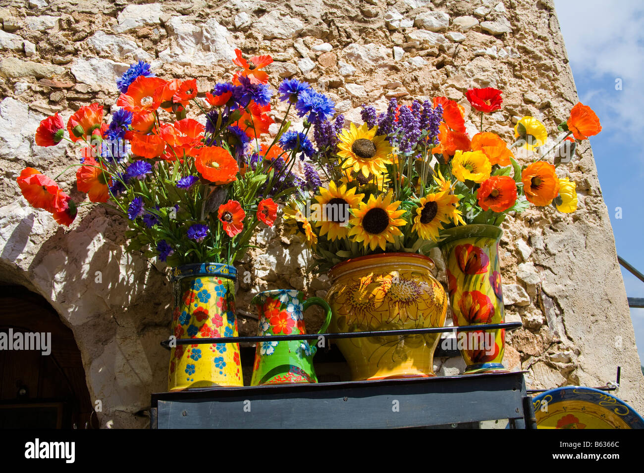 Fleurs artificielles colorées à l'extérieur d'une boutique de cadeaux dans le village médiéval d'Eze, près de Monaco, France Banque D'Images