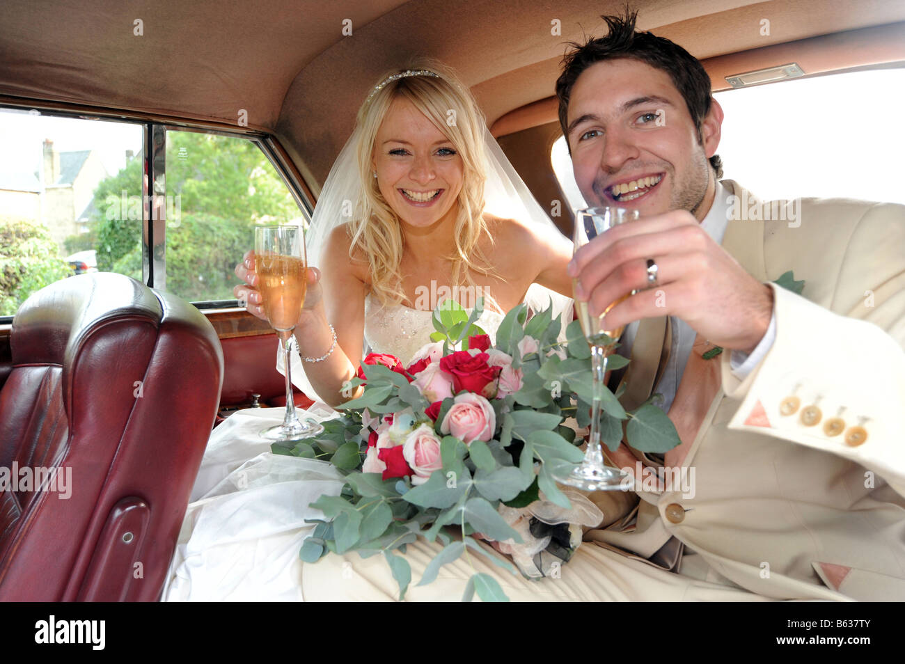 Couple de jeunes mariés à l'intérieur de leur voiture particulière. Banque D'Images