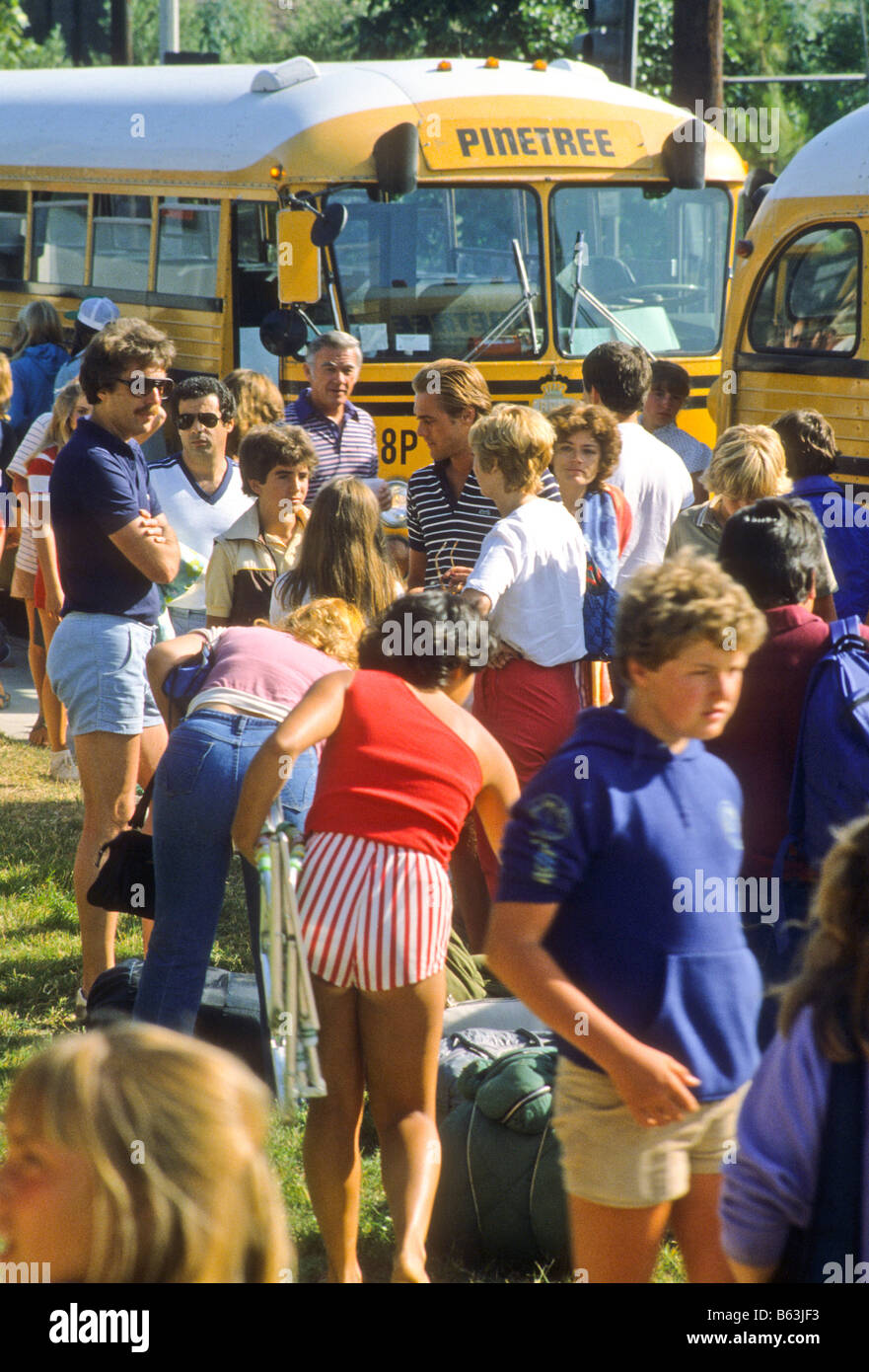 Les jeunes adolescents de décharger des autobus scolaires qui reviennent de camp d'été Banque D'Images