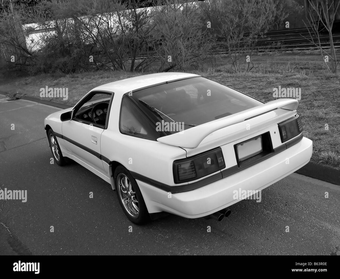 Une voiture de sport blanche garée sur le côté de la route. Banque D'Images