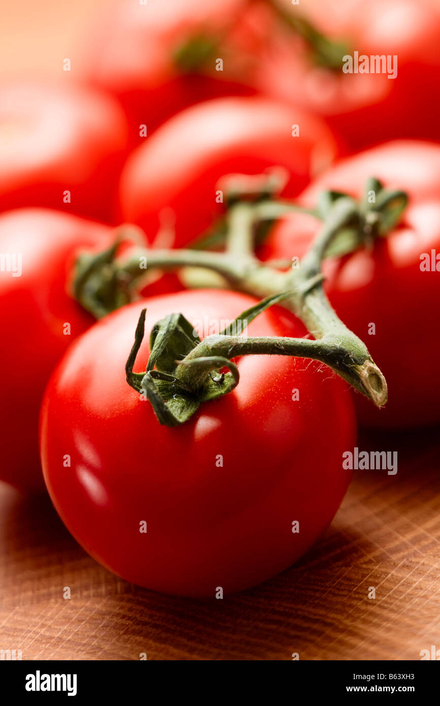 Close up of vine tomatoes on wooden surface Banque D'Images