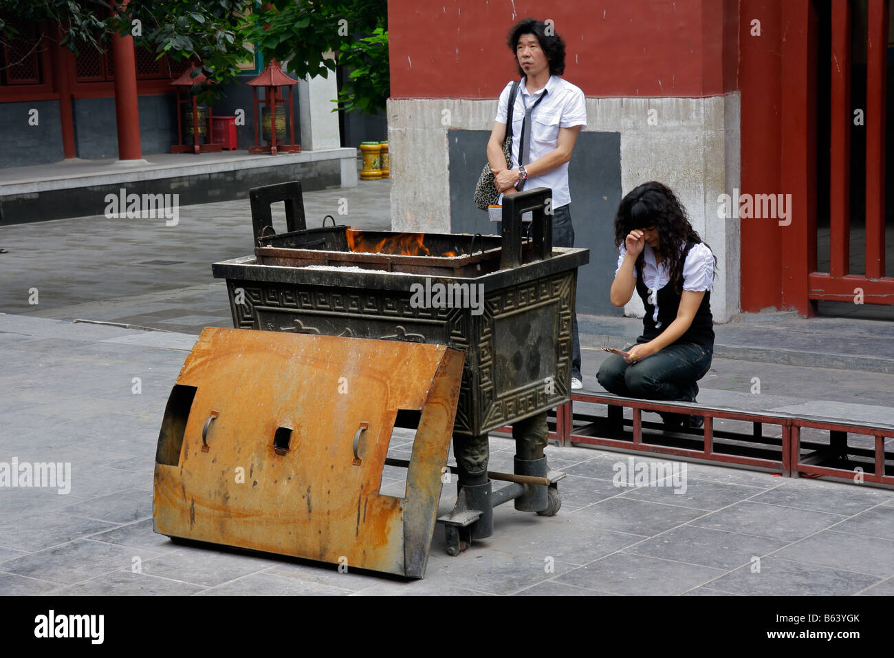 L'homme et de la femme chinoise en offrande religieuse, la combustion d'encens dans le temple YongHeGong Lama à Beijing, Chine Banque D'Images