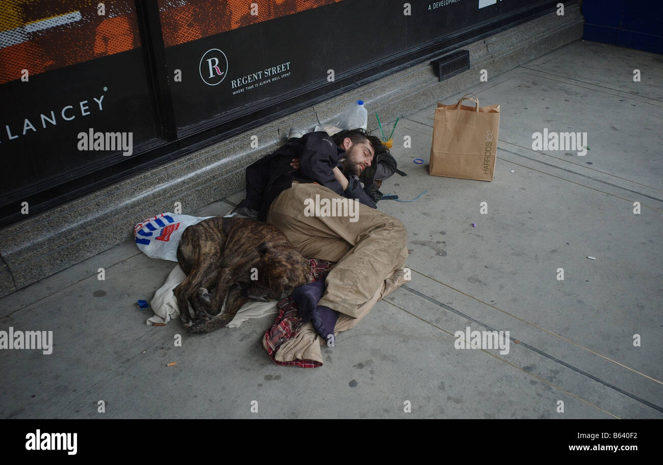 Vers le bas et hors de la rue avec son chien dans la porte d'une boutique dans Oxford Street London UK Banque D'Images