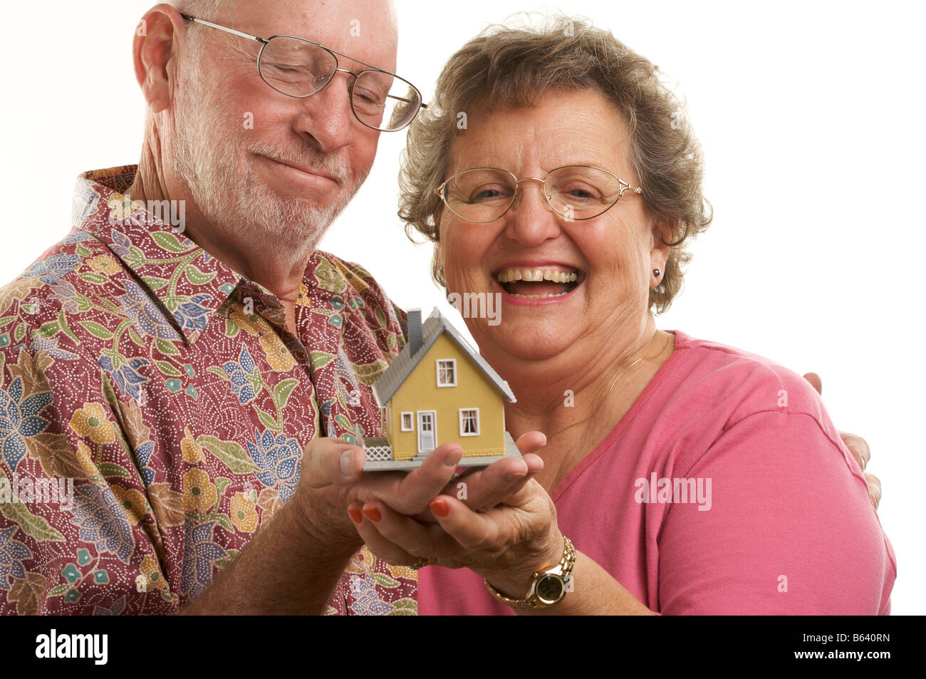 Happy Senior Couple holding a model home Banque D'Images