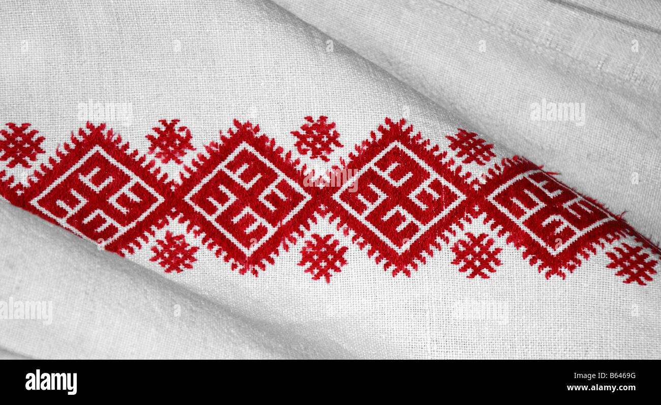Broderie rouge motif sur tissu blanc close up Banque D'Images