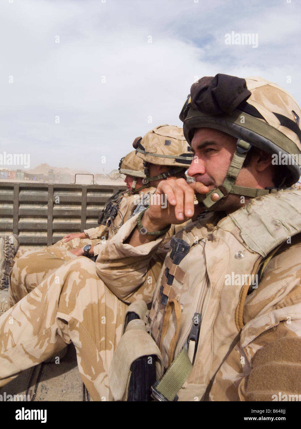 Soldat qui envisagent de porter un casque et l'armure de corps dans la province de Helmand Afghanistan véhicule Banque D'Images