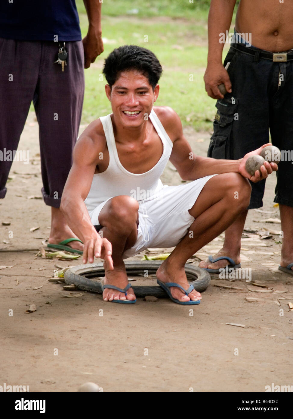 Pétanque joueur fait un jet en l'air en milieu rural au Laos Banque D'Images