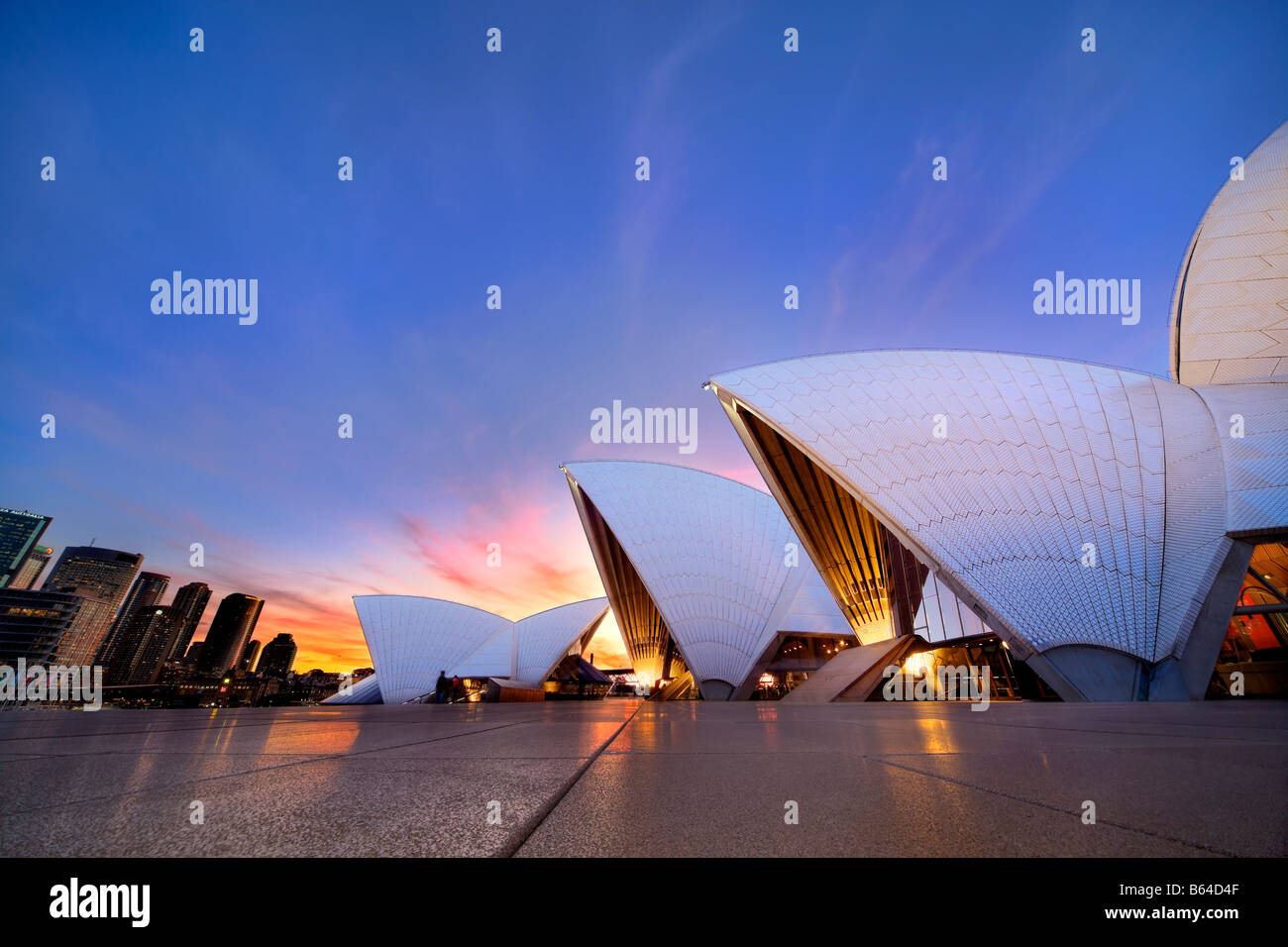 L'Opéra de Sydney avec le centre-ville de Sydney au coucher du soleil. Sydney, Australie Banque D'Images