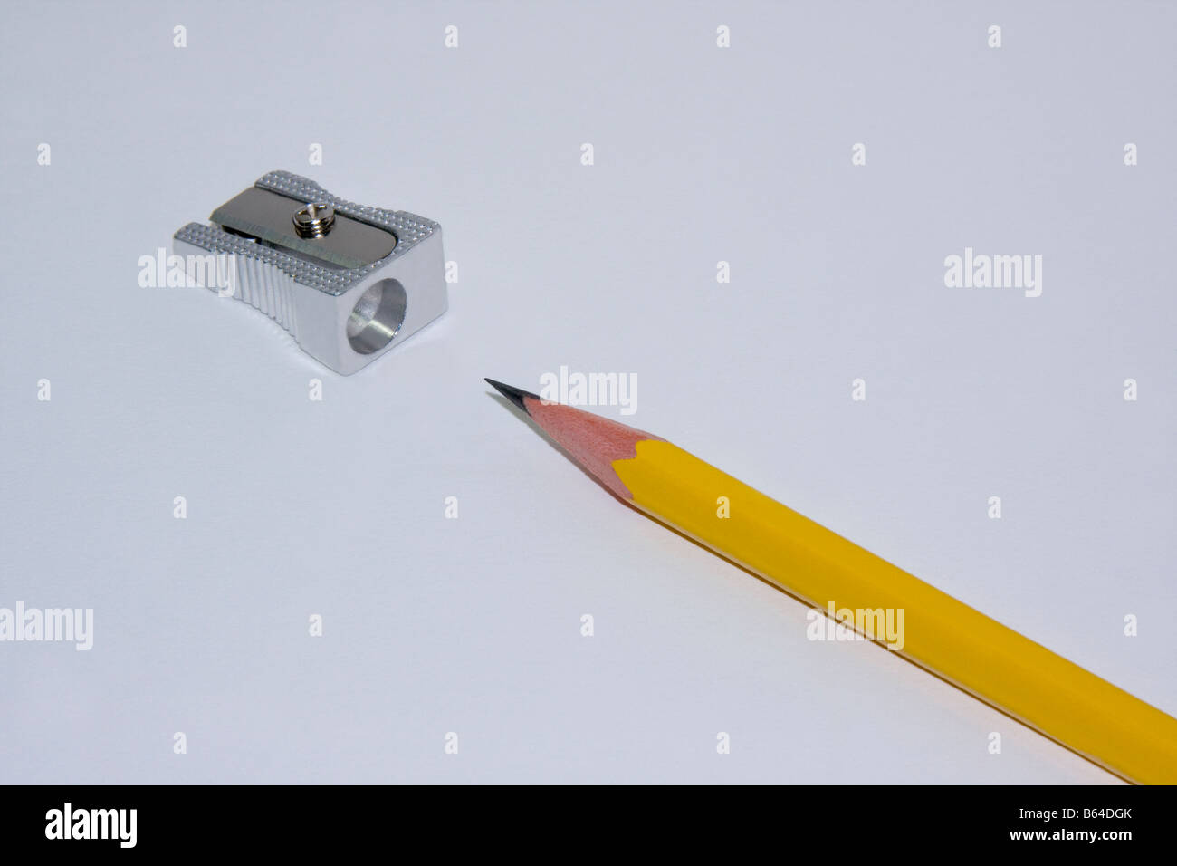 Taille-crayon et crayon jaune n°2 est posé sur une table avec fond blanc. Banque D'Images