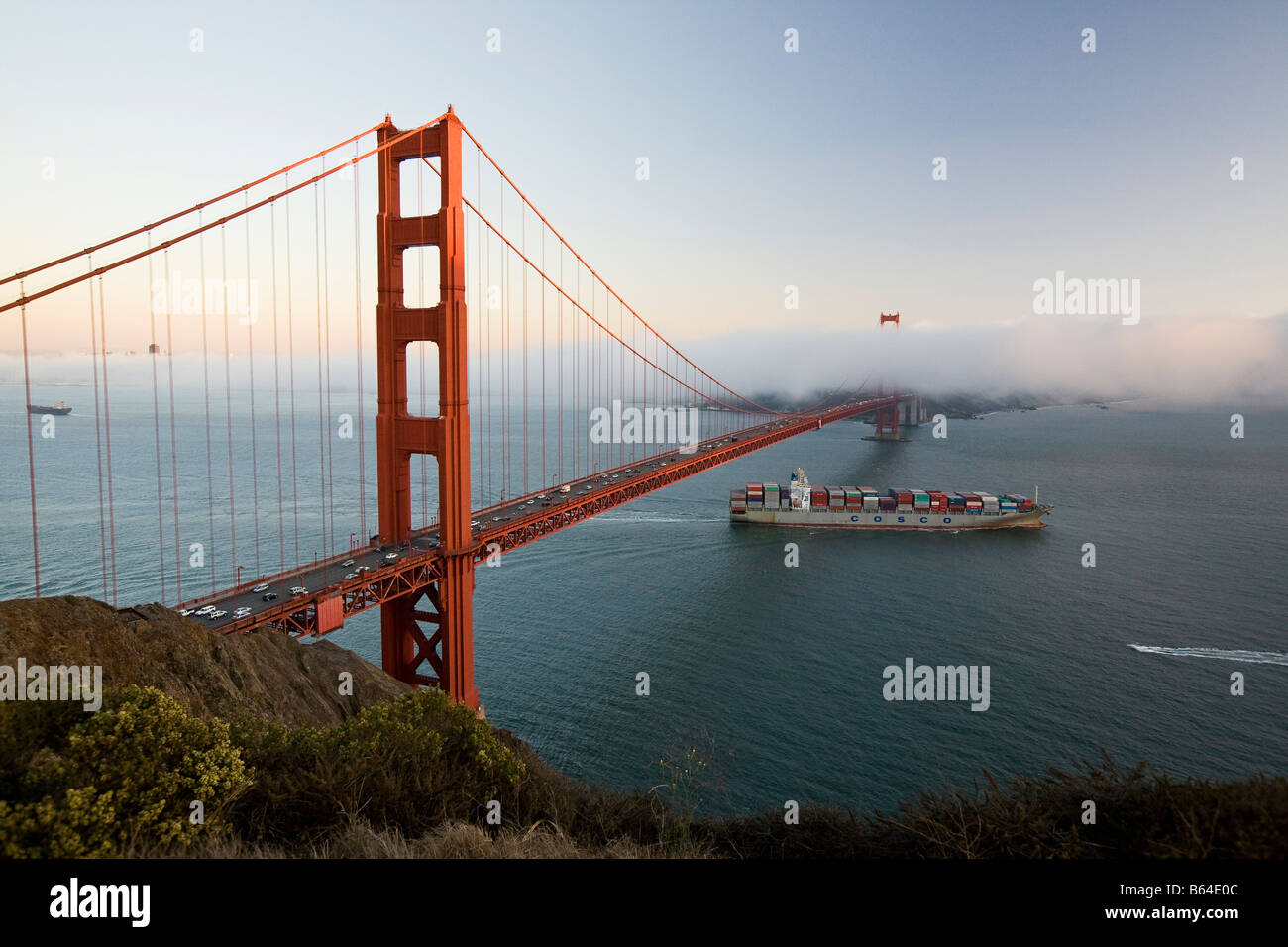 Un conteneur cargo quitte la baie de San Francisco en Californie sous le Golden Gate Bridge Banque D'Images