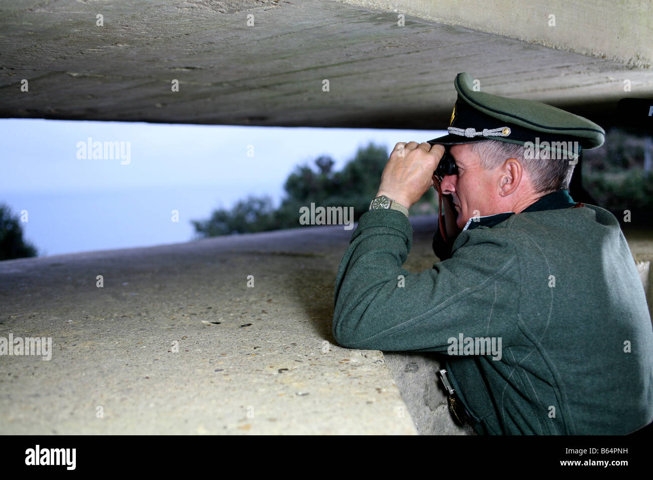 Un acteur vêtu comme un officier allemand donnant sur la Manche, à partir d'un bunker allemand Jour J en Normandie France Banque D'Images