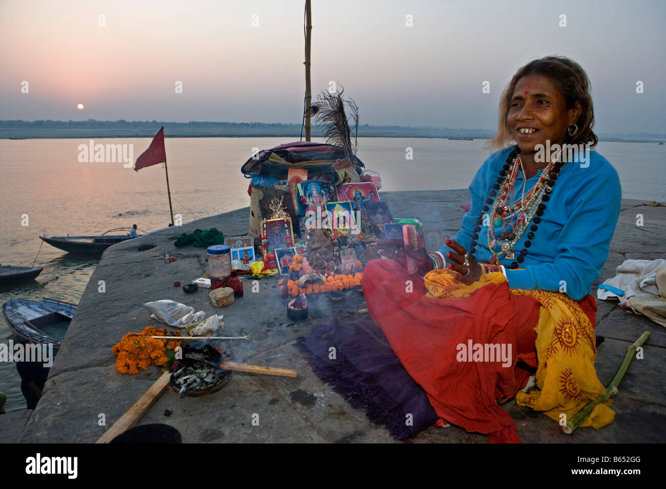 L'Inde, Uttar Pradesh, Varanasi, Gange, femme prêtre hindou de vendre des objets d'offrandes. Banque D'Images