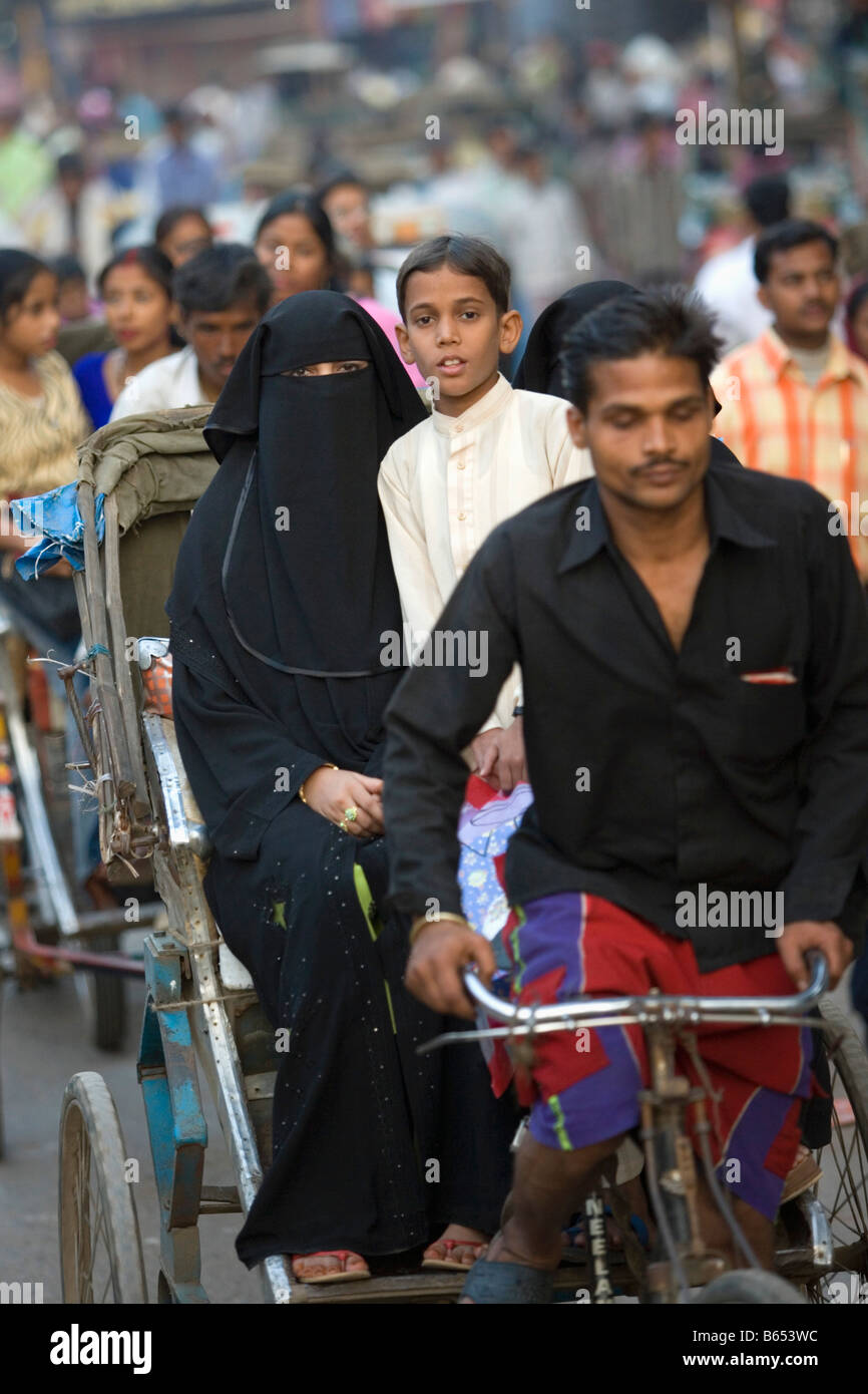 L'Inde, Uttar Pradesh, Varanasi, scène de rue. Femme voilée Moslim et fils au cycle rickshaw ou pedicap. Banque D'Images