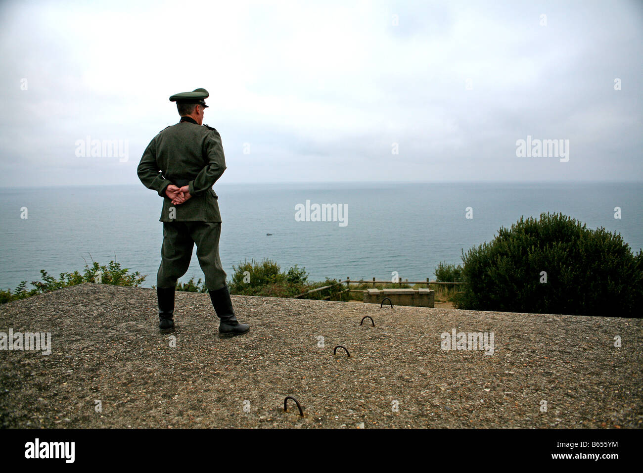 Un acteur vêtu comme un officier allemand donnant sur la Manche, à partir d'un bunker allemand Jour J en Normandie France Banque D'Images