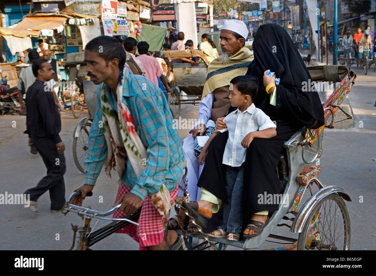 L'Inde, Uttar Pradesh, Varanasi, scène de rue. Moslim couple et fils au cycle rickshaw ou pedicap. Banque D'Images