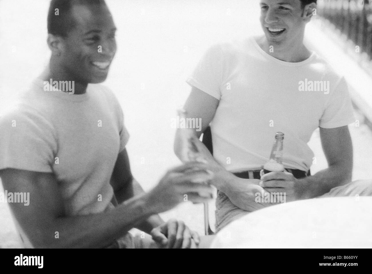 Les jeunes hommes avec des bouteilles, rire, gay Banque D'Images