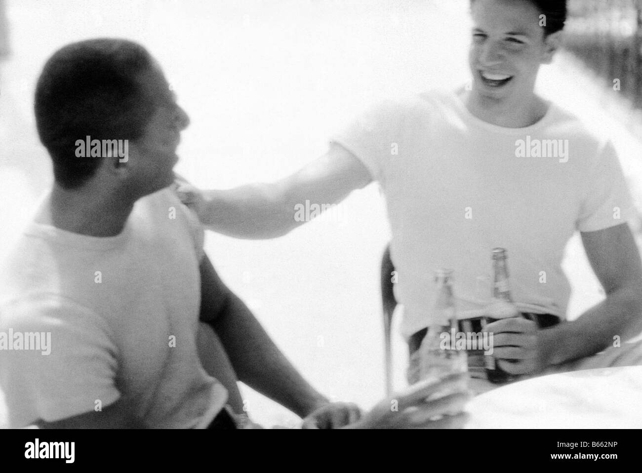 Les jeunes hommes avec des bouteilles, rire, gay Banque D'Images