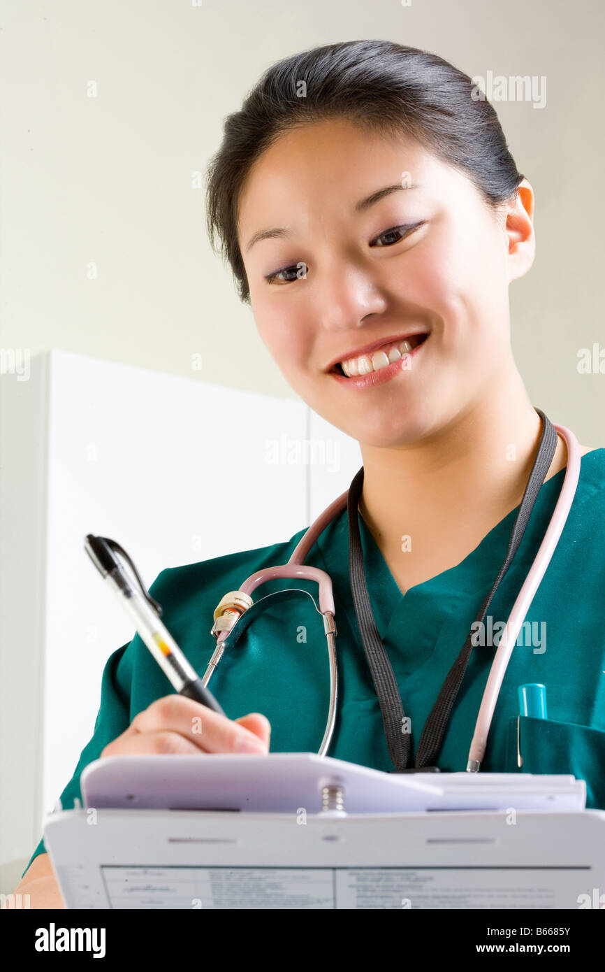 Infirmière entre dans info fiche patient. Banque D'Images