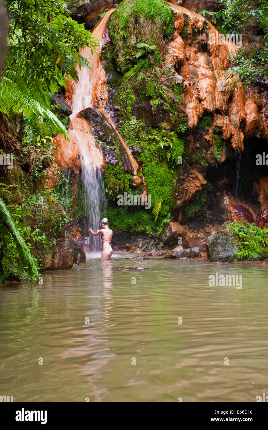 Femme prenant un bain dans la Caldeira Velha national monument Sao Miguel Açores Banque D'Images