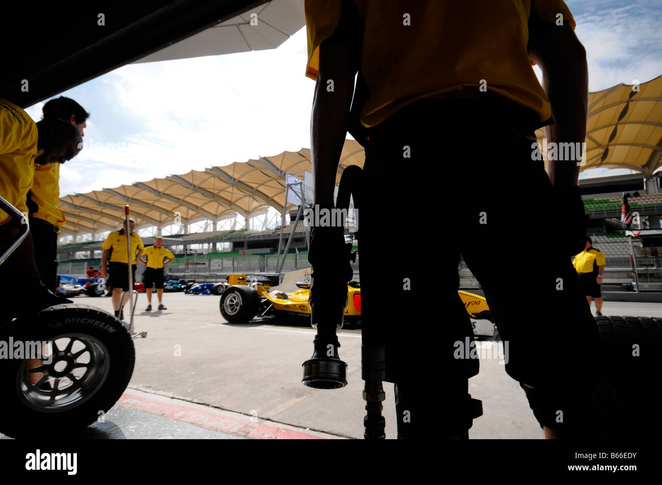 Silhouette d'un membre d'une équipe1 Malaisie pit crew se préparer pour changement de pneus à la pratique de la Coupe du Monde A1GP de Motorsport. Banque D'Images