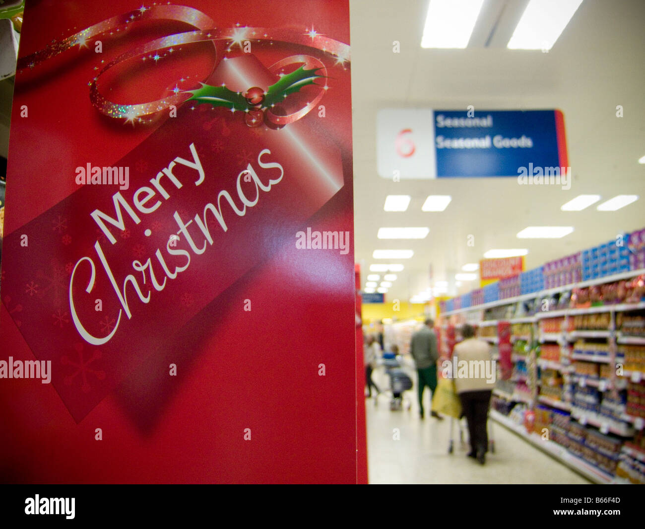Joyeux Noël shoppers accueillant signe dans un supermarché Banque D'Images