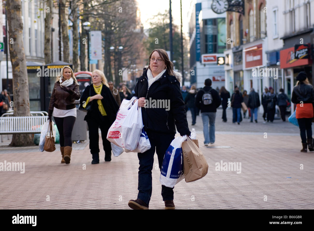 Un shopper Noël lutte avec leurs achats à Croydon, Londres. Banque D'Images