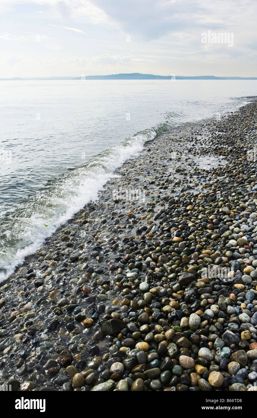 Petites vagues se briser sur les pierres qui font de la plage sur Lincoln Park à West Seattle, sur le Puget Sound Banque D'Images