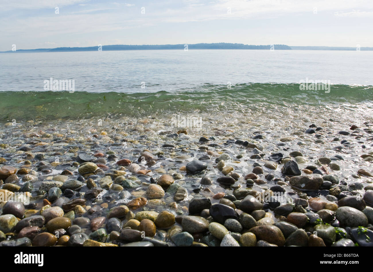 Petites vagues se briser sur les pierres qui font de la plage sur Lincoln Park à West Seattle, sur le Puget Sound Banque D'Images