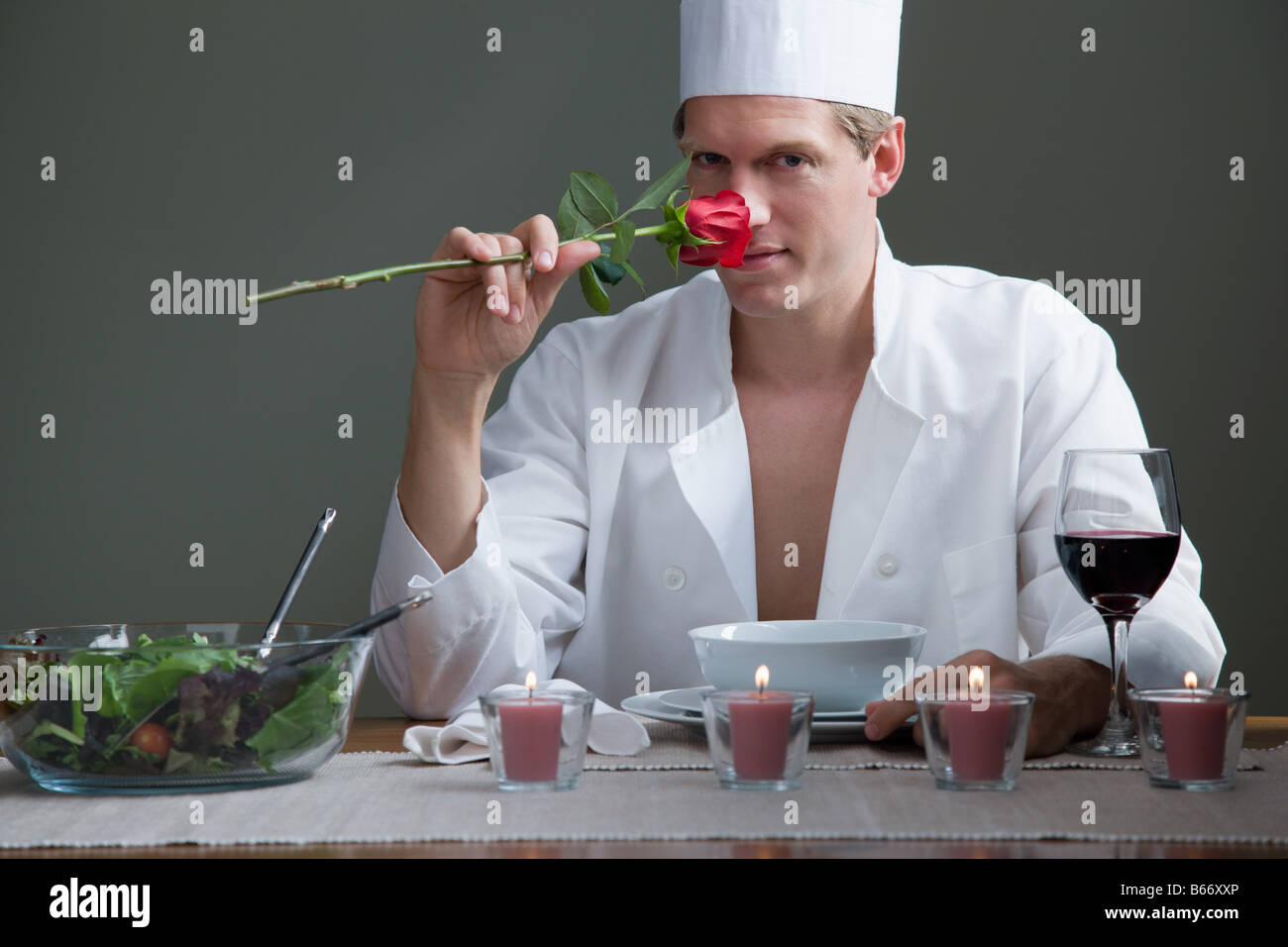 Un homme en costume chefs une rose et l'odeur d'un repas romantique Banque D'Images