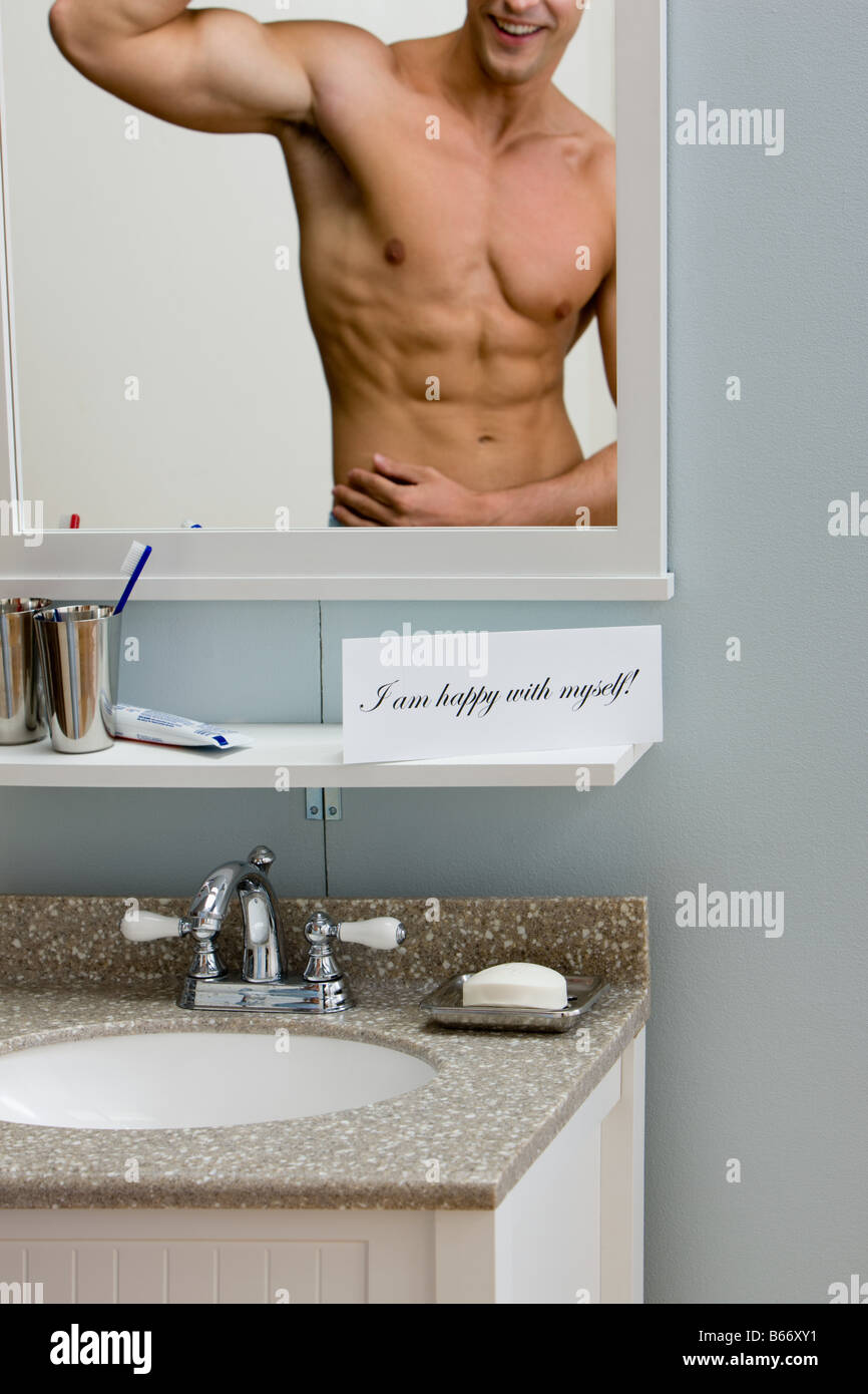 Un jeune homme à la recherche d'un miroir Banque D'Images