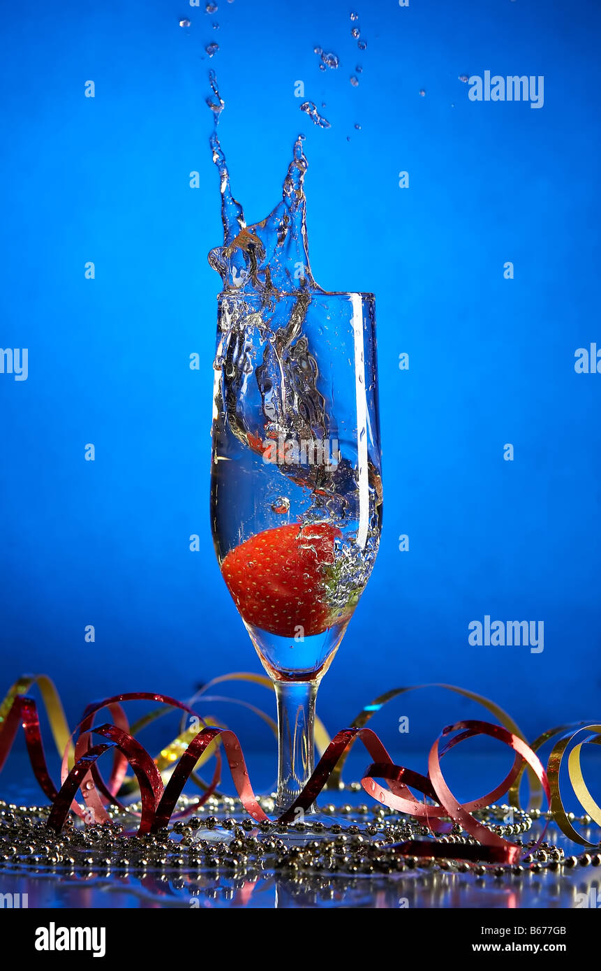 Nature morte au verre avec champagne et fraises sur le fond bleu Banque D'Images