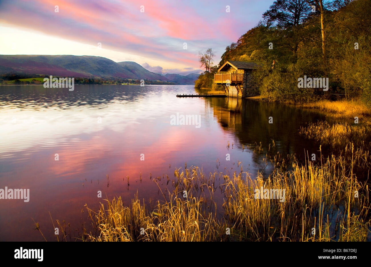 Tôt le matin, la lumière tombe sur un abri à bateaux près de Pooley Bridge sur les rives de l'Ullswater dans le Lake District Banque D'Images