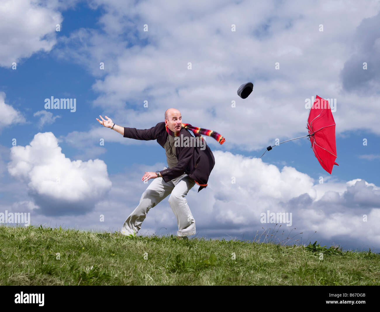 Perdre l'homme chapeau et parapluie dans le vent Photo Stock - Alamy