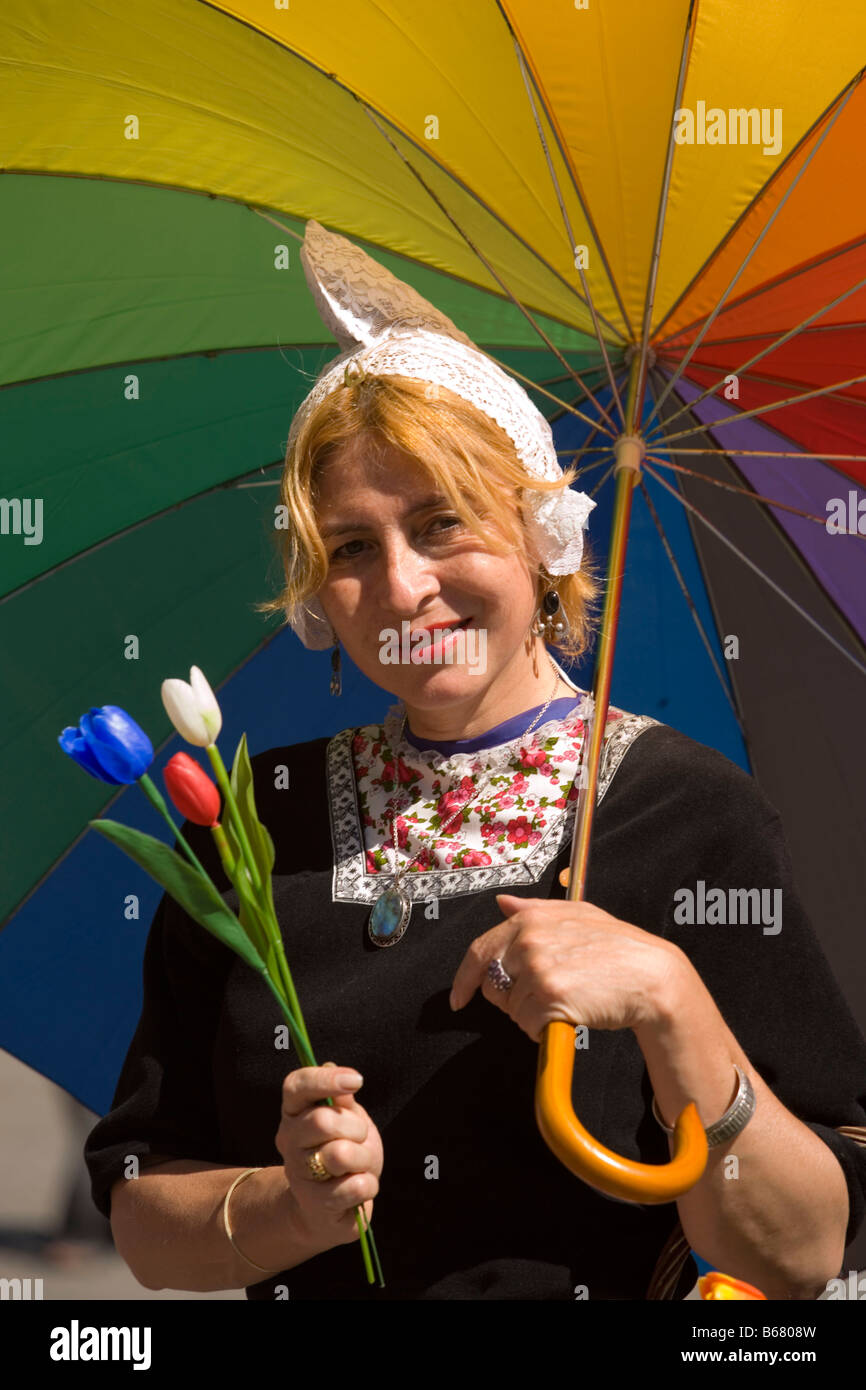 Femme en costume traditionnel néerlandais tulipes vente sur barrage, Amsterdam, Pays-Bas Banque D'Images