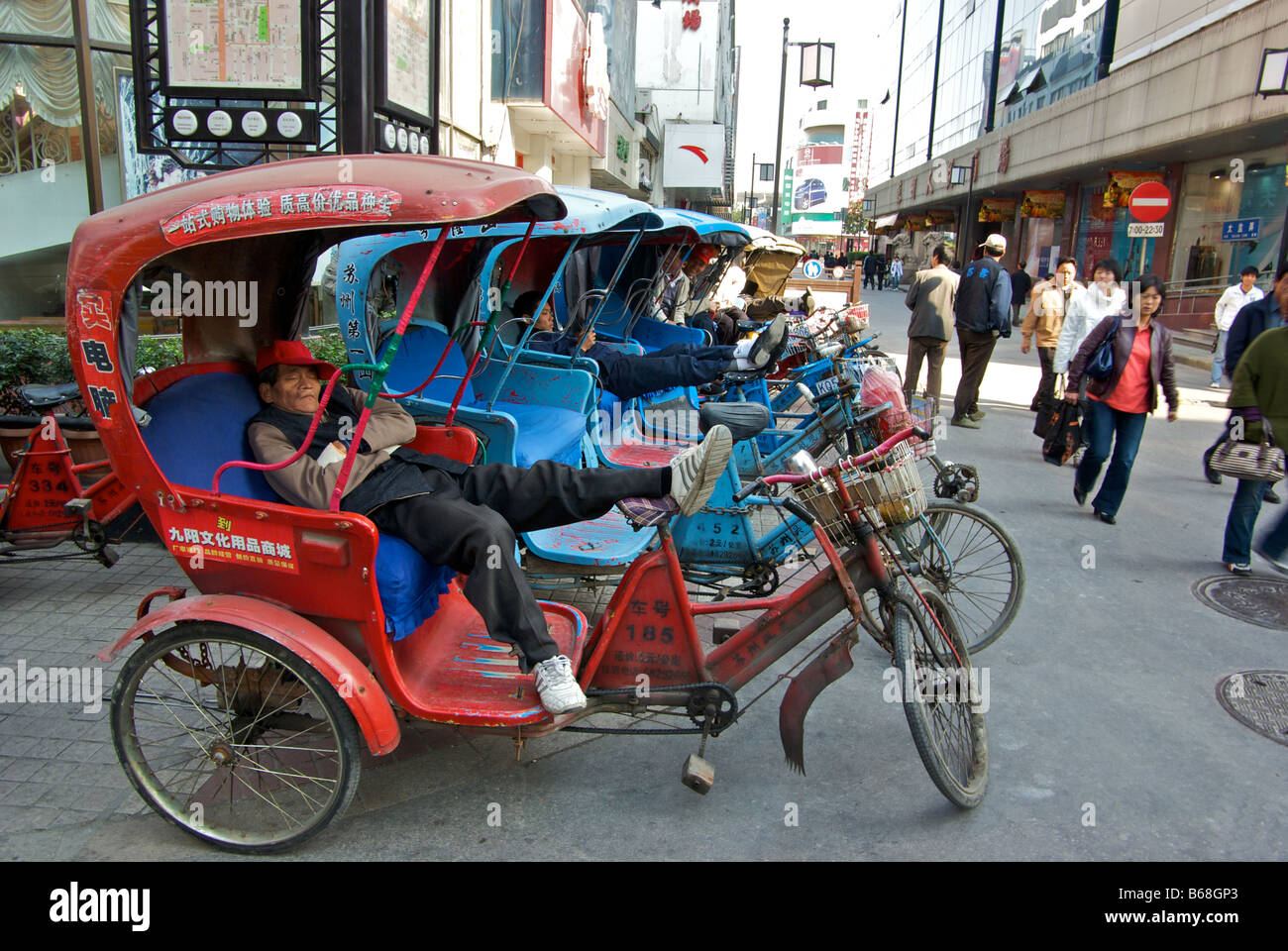 Suzhou pedicab drivers prenant une pause sieste inconscient de l'homme de la rue Banque D'Images